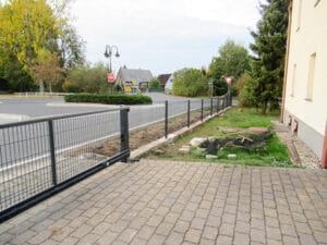 Stadtstraße mit Gehweg und Straßenschildern im Herbst.