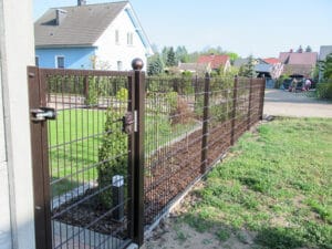 Braunes Metallgittertor vor Einfamilienhäusern.