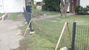 Installation eines Metallgitterzauns im Garten.