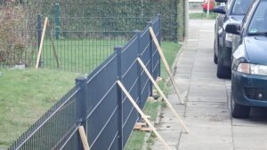 Installation eines neuen Metallzauns am Gehweg.