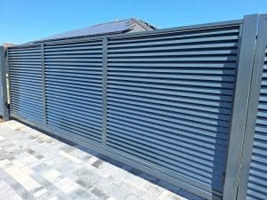 Pulverbeschichtetes Metalltor mit horizontalen Lamellen – moderne Lösung von Komabud Zaune .
