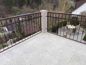 Terrasse mit schmiedeeisernem Geländer und Aussicht.