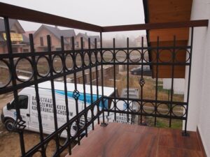 Balkon mit Geländer und Baufahrzeugen im Hintergrund.