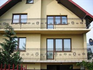Hausfassade mit Balkonen und schmiedeeisernem Geländer.