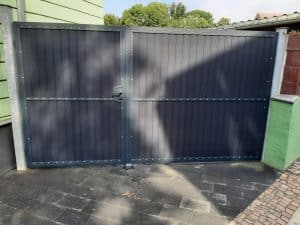 Blaues Metalltor an einer Einfahrt.