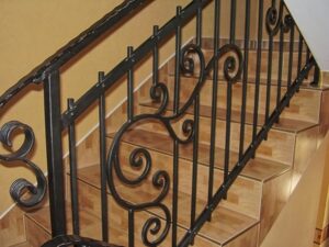 Schmiedeeiserne Treppe mit Verzierungen in Innenraum.