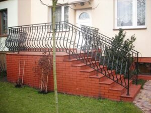 Außentreppe mit schmiedeeisernem Geländer und Ziegelstufen