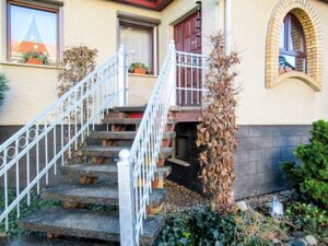 Hauseingang mit Treppe und Geländer.