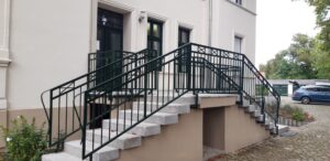 Eingangstreppe mit Geländer an einem Gebäude.