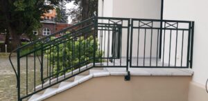 Grünes Geländer an Außentreppe.