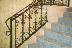 Treppe mit schmiedeeisernem Geländer und Granitstufen.