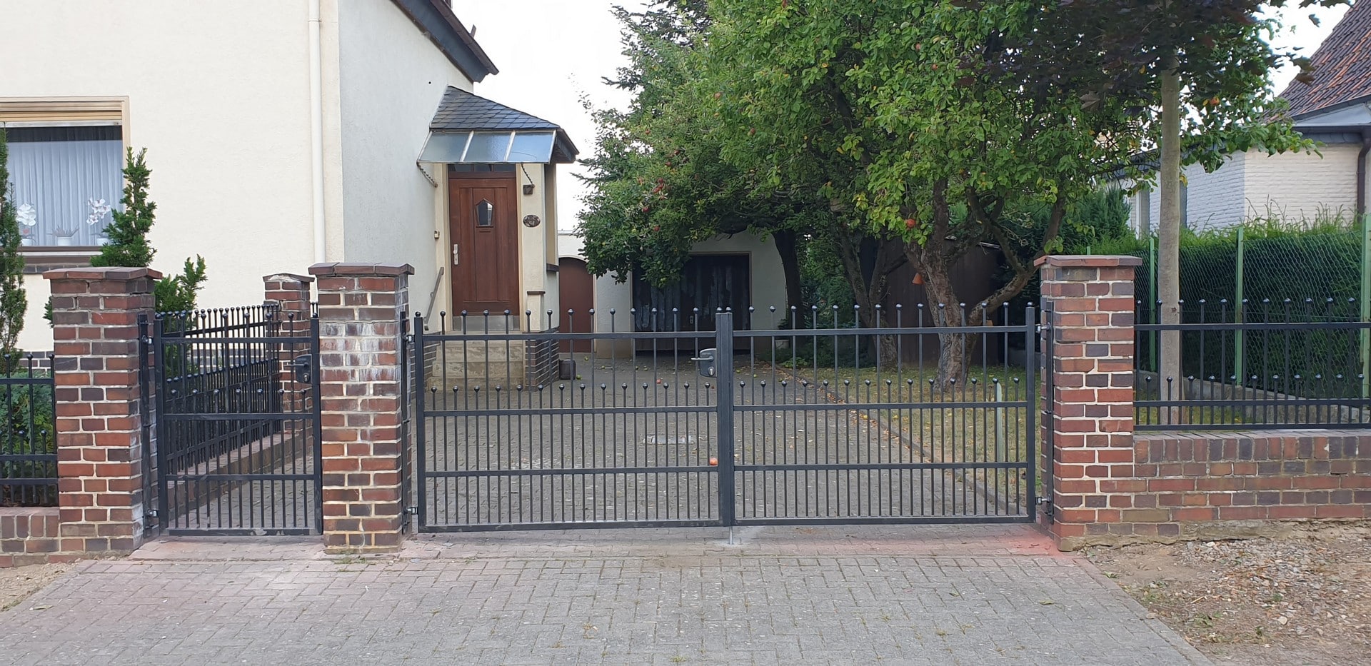 Einfamilienhaus mit Eingangstor und Baum