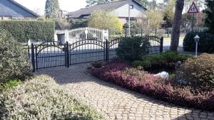 Elegantes Gartentor mit Kopfsteinpflasterweg und Hecken.