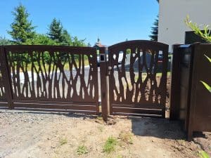 Seitliches Gartentor mit modernem Lasercut-Design in Braun – harmonische Ergänzung zum Haupteingangstor.