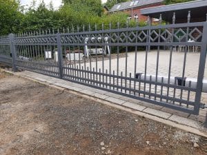 Metallzaun vor einem Haus mit Terrasse