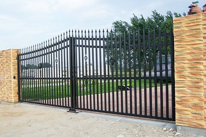 Schmiedeeisernes Tor mit Steinpfosten.