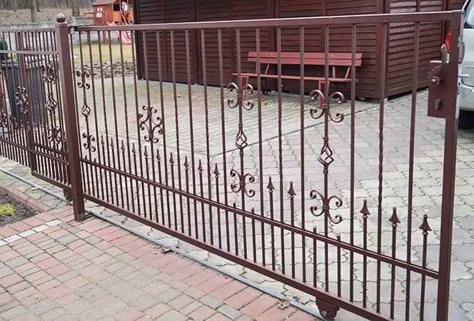 Verziertes Eisentor vor einem Wohnhaus.