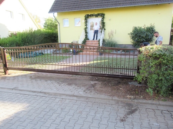 Haus mit Zaun und Person auf Treppe.