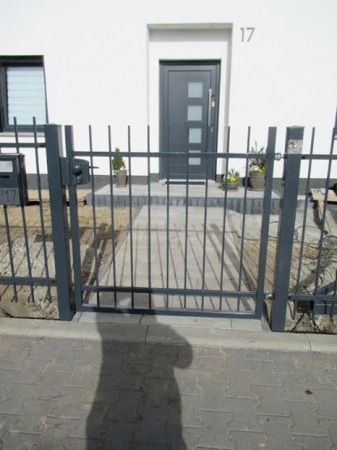 Metalltor vor moderner Haustür Nummer 17.