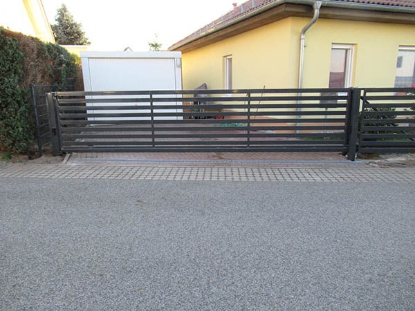 Moderne schwarze Einfahrtstor vor einem Haus.