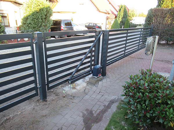 Schwarzes Schiebetor vor einem Einfamilienhaus.