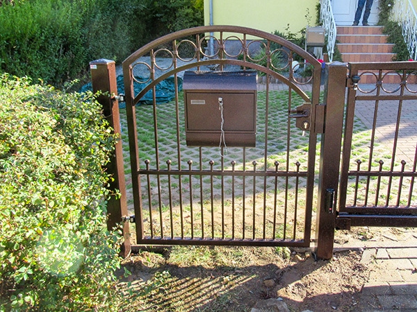 Metallgartentor mit Briefkasten und Gehweg.