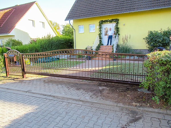 Haus mit Zaun und Person auf Veranda.