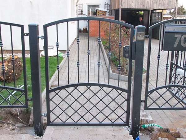 Schmiedeeiserne Gartentor an einem sonnigen Tag.