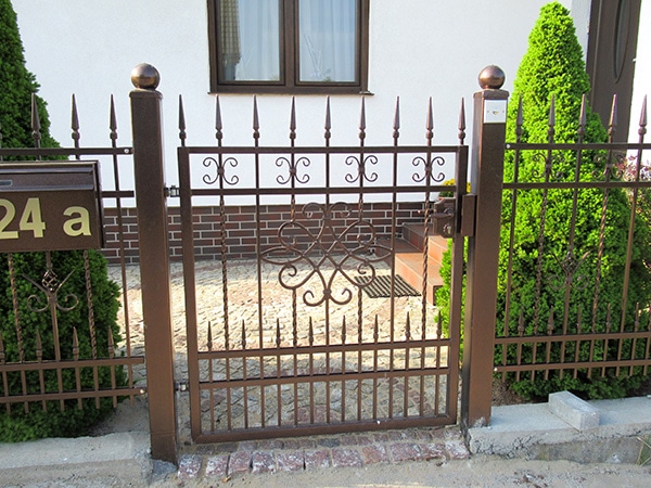 Verziertes Eisentor vor einem Wohnhaus.