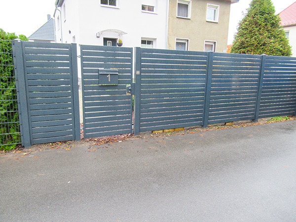 Blaues Gartentor und Zaun mit Hausnummer 1.