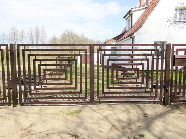 Moderne Gartentür aus Metall vor einem Haus.