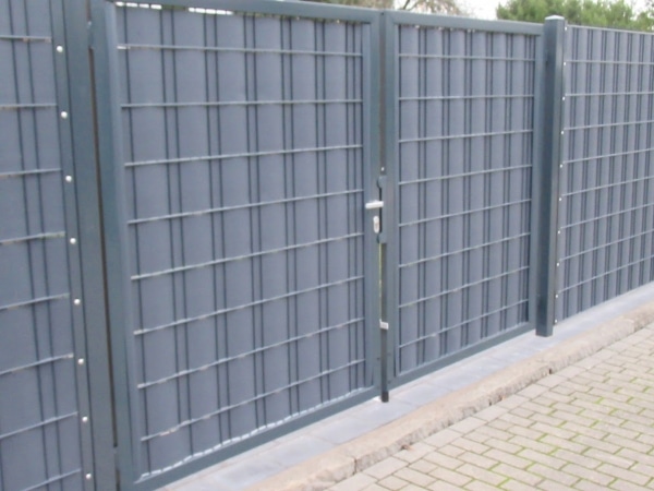 Metallgitterzaun mit Tür im Außenbereich.