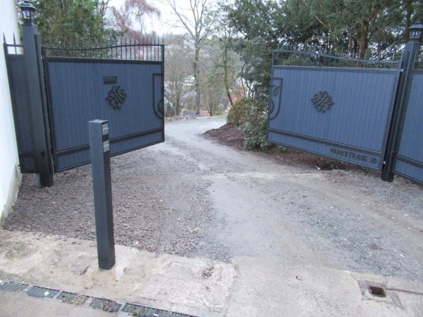 Offene Einfahrtstore mit unbefestigtem Weg.