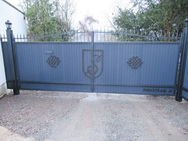 Doppelflügeliges blaues Hoftor mit Verzierungen.