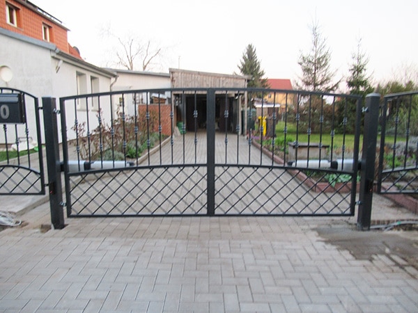 Einfahrtstor zu einem Wohnhaus mit Garten.