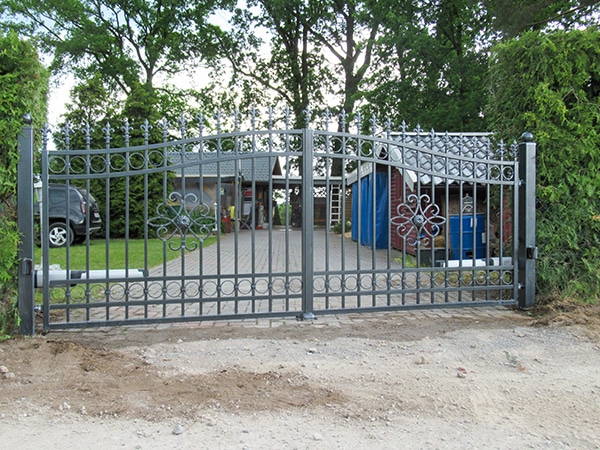 Eisernes Tor vor einem Haus mit Garten.