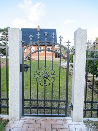 Gartentor aus Metall vor einem Einfamilienhaus.