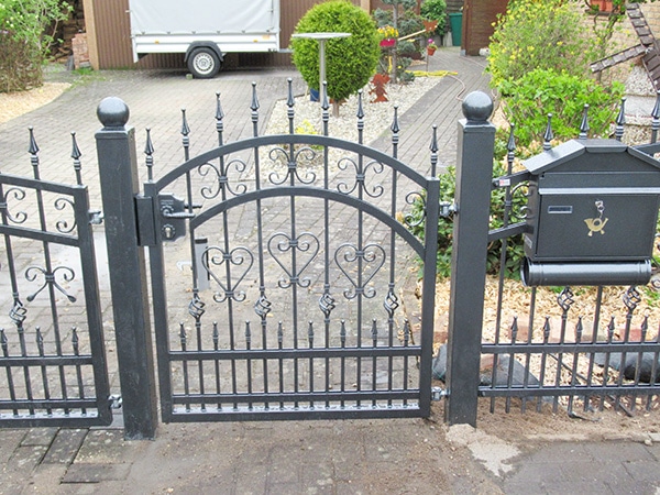 Eisernes Gartentor vor Einfahrt mit Briefkasten