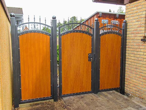 Holztor mit Metallverzierungen an einem Privathaus.