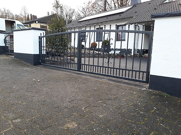 Eisernes Tor vor einem weißen Haus.