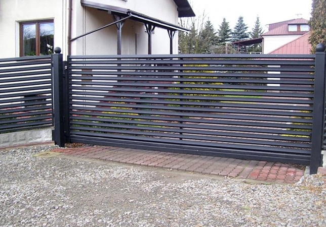 Einfahrtstor aus Metall mit Sichtschutz Lamellen.