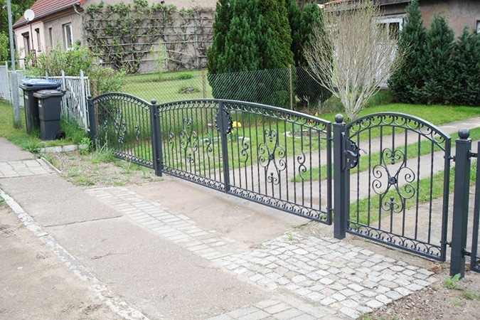 Metallenes Gartentor und Zaun mit Einfahrt.