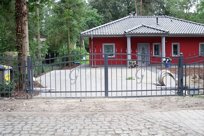 Rotes Haus mit Zaun und Einfahrt