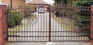 Eisernes Gartentor mit Verzierungen und Einfahrt