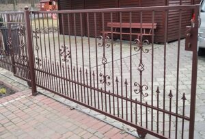 Verziertes Eisentor vor einem Wohnhaus.