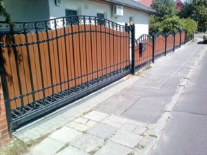 Braunes Metallzaun an einer Straße.