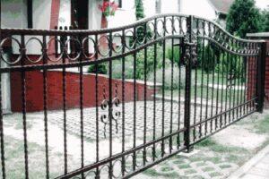 Schmiedeeisernes Tor vor einem Einfamilienhaus.