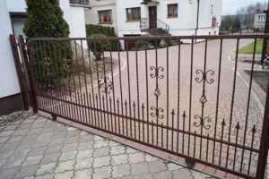 Verziertes Metalltor vor Einfamilienhaus.