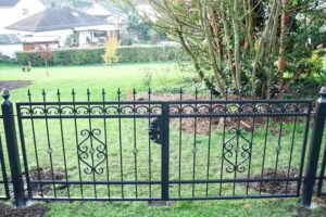 Schmiedeeisernes Gartentor mit Verzierungen, Gartenblick.