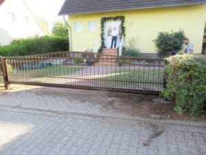 Haus mit Zaun und Person auf Treppe.